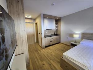 a bedroom with a bed and a kitchen in it at Apartman C437 Aparthotel Vucko Jahorina privatni apartman in Jahorina
