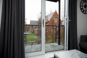 a sliding glass door with a view of a church at Luxury Ensuite Apartment with shared living room and kitchen in Manchester