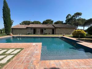 a swimming pool in front of a house at VILLA VITELLINO in Castiglione del Lago