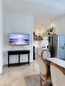 eine Küche mit einem Tisch und einem TV an der Wand in der Unterkunft Ara Santvana Villa Bali in Legian