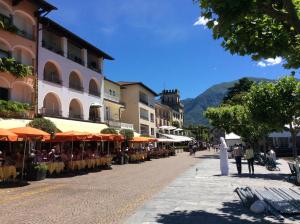 Une rue dans une ville avec une femme en robe dans l'établissement Bicledro by Fewotessin, à Ascona