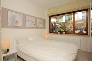 una camera da letto bianca con un letto e una finestra di Collina d'Oro C14 by Fewotessin a Orselina