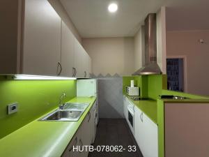 una cocina con encimeras verdes y blancas y fregadero en Palau de la música 2, en Barcelona
