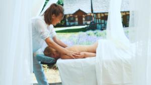 a woman is giving a man a massage at Lawendowa Osada in Przywidz