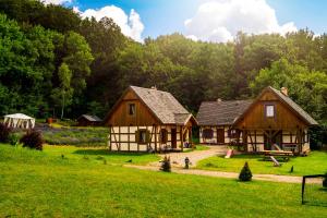 two wooden houses in a field with trees at Lawendowa Osada in Przywidz