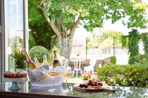 a table with glasses of wine and a plate of food at Grace Road Cottage in Tauranga