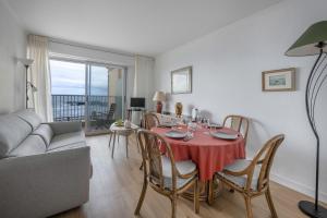 a living room with a table with chairs and a couch at Vue mer - appartement pour 2 au Croisic in Le Croisic