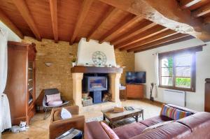 a living room with a couch and a fireplace at Maison pour 6 avec piscine et grand jardin in Plazac