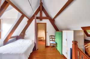 a attic room with a bed and a chair at Maison pour 6 avec piscine et grand jardin in Plazac