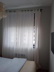 a bedroom with a bed and a window with white curtains at Maršal, Titova vila in Zlatibor +12 photos