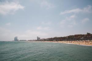 バルセロナにあるCatalonia Barcelona Beachの水中の人々の集まりがある海岸