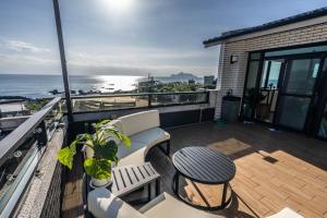 un balcone con tavolo e sedie e l'oceano di 眺浪島民宿 a Fan-shu-liao