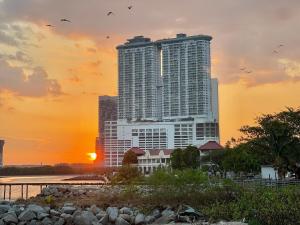 a tall building with the sunset in the background at PortugueseSeaVilla 26pax in Melaka