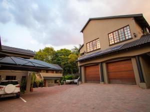 a house with two garage doors in a driveway at Casa Albergo Corporate Guest House in Pretoria