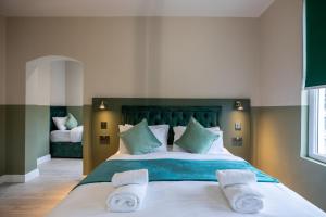 伦敦The Chapter Hotels - Finsbury Park的一间卧室，有一张大床，床上有毛巾 更多37张照片