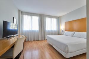 una habitación de hotel con una cama y un televisor en Catalonia Barcelona Beach, en Barcelona