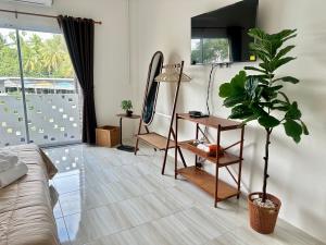 a living room with a couch and a potted plant at Twins cafe & Room in Suratthani