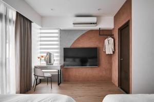una camera da letto con scrivania e TV a parete di 眺浪島民宿 a Fan-shu-liao