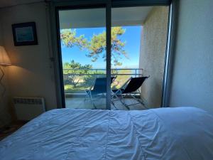 a bedroom with a bed and a view of a balcony at C2111 Appartement Vue Mer Terrasse, Parking in Arcachon
