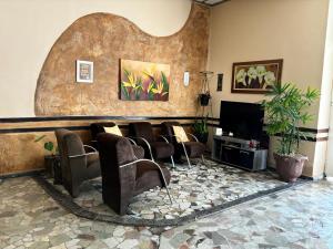 a waiting room with chairs and a flat screen tv at Hotel Colonial Bragança Paulista in Bragança Paulista