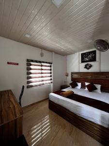 ein Schlafzimmer mit großem Bett und Fenster in der Unterkunft The Svarga Munnar Hill View resort in Munnar