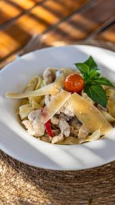 a white bowl of food with pasta and a tomato at Chillos Beach in Marmaris