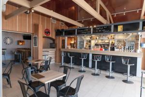 a restaurant with tables and chairs and a bar at Vacances Bleues Club Keravel in Carnac