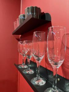 a row of wine glasses sitting on a counter at Le boudoir rouge - Loveroom luxueuse pour couples in La Ferté-Gaucher