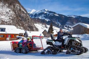 a group of people riding on a atv in the snow at Alpen Hotel Post in Au im Bregenzerwald