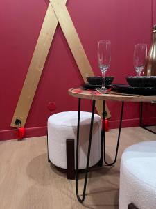 a table with two wine glasses on top of it at Le boudoir rouge - Loveroom luxueuse pour couples in La Ferté-Gaucher +27 photos