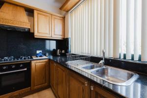 a kitchen with a sink and a stove at Mellieha Villa W Jacuzzi And Pool Table By Homely! in Għajn Żejtuna +74 photos
