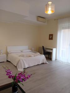 a white bedroom with a bed and a desk at Affittacamere Lusitana Alloggi 2 in Foligno