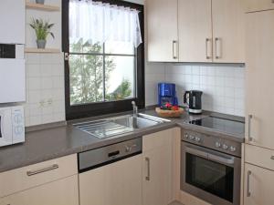 a kitchen with a sink and a window at Ferienhaus Nr 48, Kategorie Komfort, Feriendorf Hochbergle, Allgäu in Lechbruck