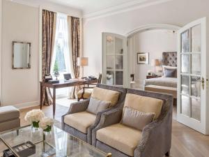 a living room with a couch and a bed at Fairmont Hotel Vier Jahreszeiten in Hamburg