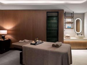 a hotel room with two beds and a mirror at Mövenpick Living Istanbul Saklivadi in Istanbul