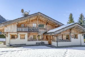 a large wooden house with snow on the ground at Chalet Glisse in Megève