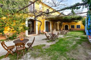 a patio with tables and chairs and a building at MAS DE BERNIS - Masia in L'Aldea