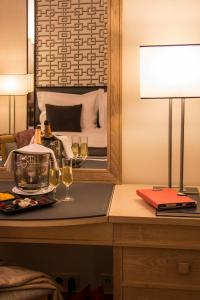 a table with two glasses of wine and a mirror at Hotel Mundial in Lisbon