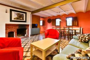 a living room with red furniture and a fireplace at MAS DE BERNIS - Masia in L'Aldea