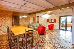 a dining room with a table and a couch at MAS DE BERNIS - Masia in L'Aldea