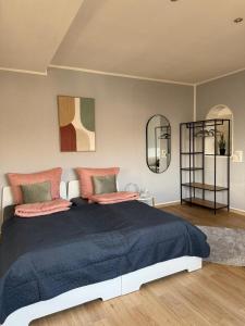 a bedroom with a large bed and two mirrors at Schickes Apartment am Rhein in Koblenz