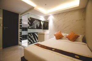 a bedroom with a large white bed with orange pillows at Double Five in Bangkok