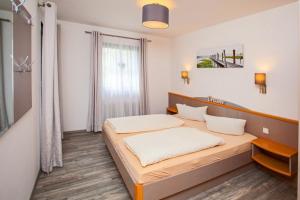 a bedroom with a bed and a window at Ferienhaus Nr 49, Kategorie Premium, Feriendorf Hochbergle, Allgäu in Lechbruck