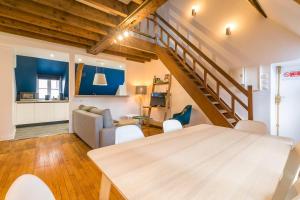 a living room with a dining room table and a staircase at LA Plume aux pieds du Parvis Saint Jean in Dijon
