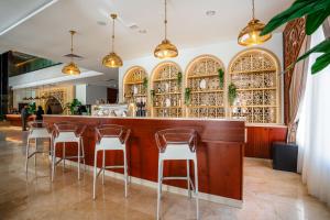 a bar with chairs and wine bottles at Marhaba Plaza Hotel in Tripoli