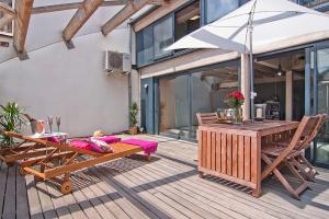 um deque de madeira com uma mesa e um guarda-chuva em My Space Barcelona Executive Apartments Center em Barcelona