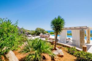 a view of a resort with a pool and palm trees at Villa Torre del Sasso in Marina Porto