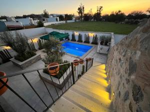 a villa with a swimming pool at sunset at Casa Frida con Piscina Privada Caliente, Aire Acondicionado, Billar, Parrilla & FirePit in San Miguel de Allende