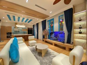 un salon avec un canapé blanc et une télévision dans l'établissement HT Sea Villa - 7 Bed Rooms, à Hạ Long
