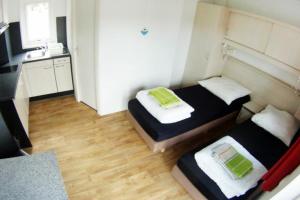 a small room with two beds and a kitchen at MADRID - Studio mit Sandstrand & Seeblick nahe Rhein-Main und Spessart in Kahl am Main